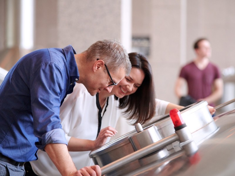 Ein Mann und eine Frau betrachten interessiert Objekte in einer Ausstellungsvitrine.