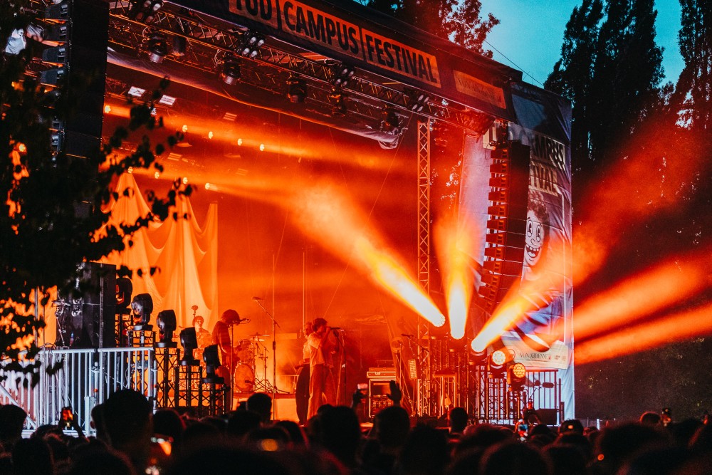 Live-Musik auf einem Festival: Eine Band spielt vor großem Publikum mit Lichteffekten.