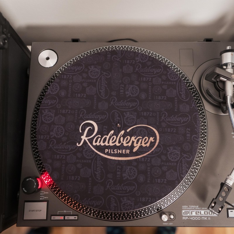 Ein Plattenspieler mit einem speziell bedruckten Plattenteller und einem Tonarm rechts.