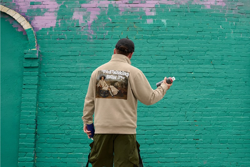 Ein Sprayer steht vor einer Wand, er trägt einen Pullover mit der Aufschrift - Overthinking ruins it.